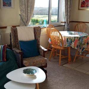 GrangeArmada Lodge Seashore Holiday Apartment的客厅配有桌子、椅子和桌子。