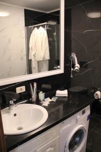 巴甫洛达尔Golden Park Hotel的一间带水槽和洗衣机的浴室