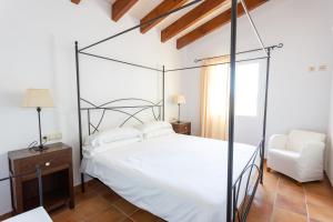 苏昂博Villas Finesse By MENORCARENTALS的一间卧室配有四柱床和椅子