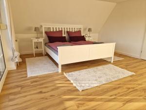 索尔陶Heideherz的一间卧室配有一张带红色枕头的床和2个地毯。