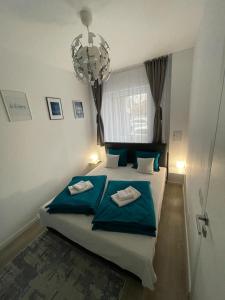 奥拉迪亚Phoenix Luxury Apartment的一间卧室配有一张带蓝色床单和吊灯的床。