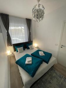 奥拉迪亚Phoenix Luxury Apartment的一间卧室配有一张带蓝色床单和吊灯的床。