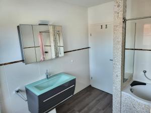 格洛米茨Anker Perla的浴室设有蓝色水槽和镜子