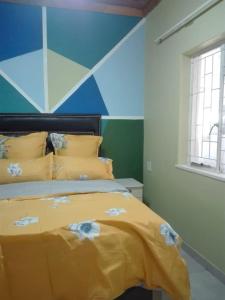 开普敦ALEXIA LODGE & SPA的一间卧室配有一张黄色的床和蓝色的墙壁
