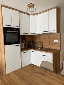 ŠišavaApartman Green的小厨房配有白色橱柜和水槽