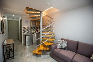 卡尼奥提Artemida Suites的带沙发的客厅内的螺旋楼梯