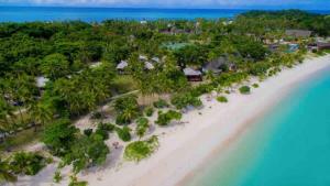 玛娜岛Mana Lagoon Backpackers的享有树木繁茂的海滩和海洋的空中景致