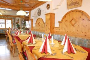 纽科琴格罗斯夫桑尼可旅馆的用餐室配有红色和白色餐巾桌