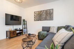 埃森EasyGreen moderenes Appartment - Essen by EasyHood的带沙发和电视的客厅