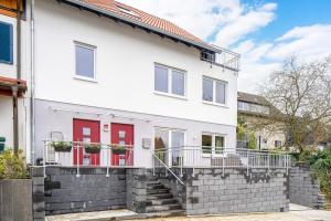 埃森EasyGreen moderenes Appartment - Essen by EasyHood的白色的房子,有红色的门和楼梯