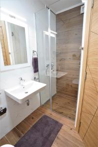 诺维萨德Sky Apartments Novi Sad的浴室配有白色水槽和淋浴。