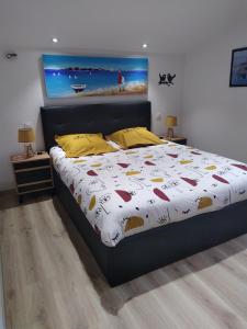 Champagné-les-MaraisOCEANE的一间卧室配有一张带白色床罩和黄色枕头的床。