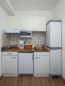 孔茨Park Hotel的厨房配有白色橱柜、水槽和微波炉