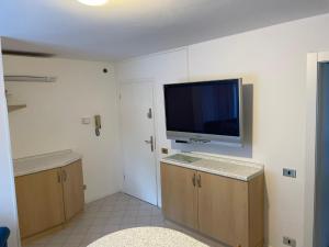 圣佩莱格里诺温泉San Pellegrino Solarium Apartment的墙上配有平面电视的房间