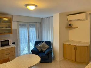 圣佩莱格里诺温泉San Pellegrino Solarium Apartment的客厅设有蓝椅,厨房设有