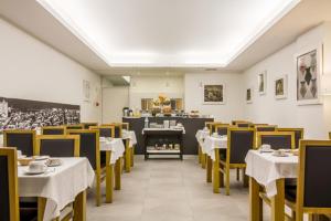 维亚纳堡拉兰热拉酒店的用餐室配有白色的桌子和黄色的椅子