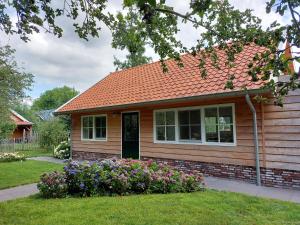 Hazerswoude-RijndijkLodges near the Rhine - Sustainable Residence的院子里有鲜花的小房子