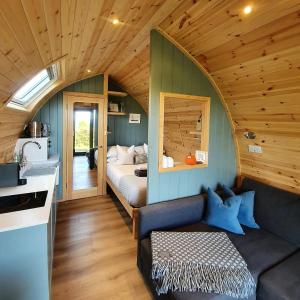 威尔斯浦Odli Glamping - Luxury Glamping Pod的一间房子里配有沙发和一张床的房间