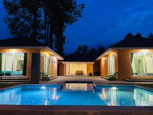 卡农卡农花园套房旅馆的夜间在房子前面的游泳池
