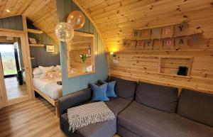 威尔斯浦Odli Glamping - Luxury Glamping Pod的客厅配有沙发和1张床