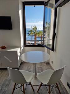 滨海萨纳里Sanaritz的配有大窗户的客房内的白色桌椅