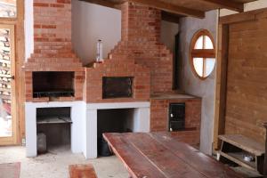 Lunca de SusBrigigyop的客房内的砖砌壁炉及木桌