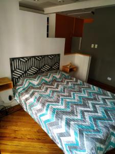 布宜诺斯艾利斯Departamento Unico en Recoleta !! Ubicacion Excelente.的一间卧室配有一张带五颜六色棉被的床