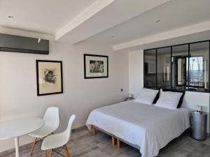 滨海萨纳里Sanaritz的卧室配有一张床和一张桌子及椅子