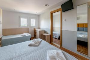 里米尼斯特雷萨酒店的酒店客房,设有两张床和镜子