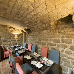 巴黎奥斯丁圣拉扎尔酒店的一间带桌椅和石墙的用餐室