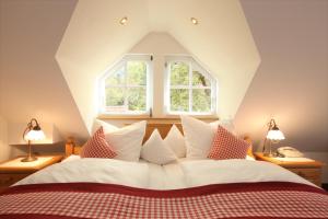 卡佩尔罗德克红斯万德幕酒店的一间卧室配有一张带红色和白色枕头的大床