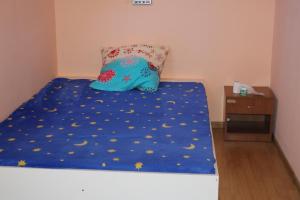 Lunca de SusBrigigyop的一张带蓝色棉被和枕头的床
