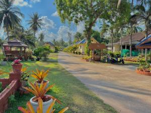 Thungwua laen resort的村庄里一条有房屋和棕榈树的街道