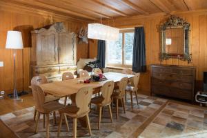 伦策海德Residence for 12 persons Chalet Crestas-Lenzerheide的一间带木桌和椅子的用餐室