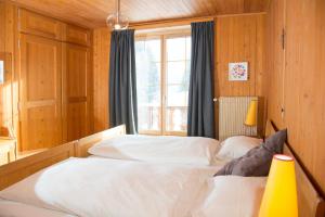 伦策海德Residence for 12 persons Chalet Crestas-Lenzerheide的一间卧室设有两张白色的床和窗户
