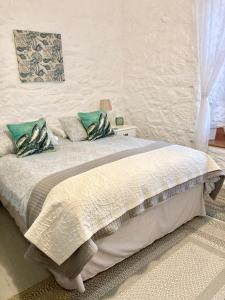 圣贾斯特The Old Post House B&B的卧室配有带绿色枕头的大型白色床