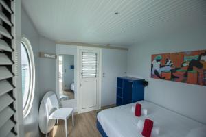 豪特尔Aqualodge, Les Saintes, Terre de Haut的卧室配有一张床,墙上挂有绘画作品