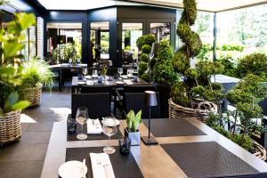 格罗斯梅克森施罗德酒店&餐厅的一间设有桌椅和盆栽的餐厅