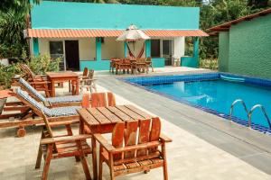 莫罗圣保罗Ajubá Pousada的一个带桌椅的游泳池的度假酒店