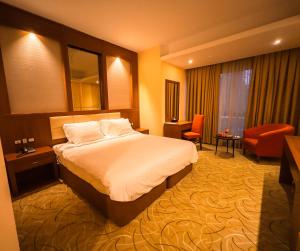 巴格达Shaheen Hotel Baghdad的大型酒店客房,配有床和椅子