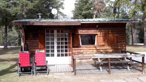 CamuracCabane randonneur au camping的小木屋配有2把椅子和桌子