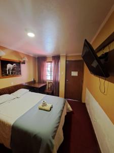 瓦拉斯Hotel la casona的配有一张床和一台平面电视的酒店客房