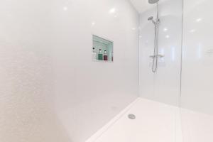 格兰奇奥沃桑茨The Pheasant Inn的白色的浴室设有玻璃门淋浴