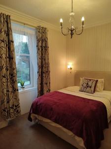 珀斯度纳兰旅馆的一间卧室配有一张带吊灯和窗户的床。