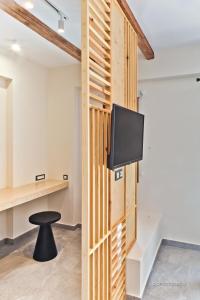 Kyra PanagiaYpsilos Beach Suites的一间带电视和凳子的墙壁的房间