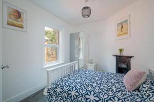 考斯3 Anzac Cottage的一间卧室设有蓝色和白色的床和2个窗户。