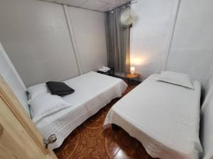 戈尔菲托Casa Congo的小房间,带两张床,上面有黑包