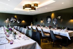 格罗斯梅克森施罗德酒店&餐厅的餐厅的一排桌子,配有白色的桌布