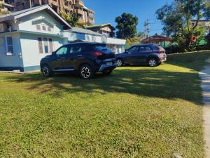 焦尔哈德Gianna Homestay的两辆汽车停在房子旁边的院子