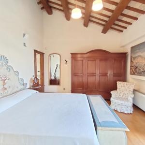 西尼加利亚Villa Adele Senigallia的卧室配有一张白色大床和一把椅子